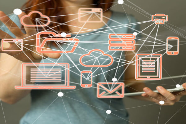 Person holding a tablet with floating orange network icons (cloud, email, laptop, phone) to show digital connectivity and cloud computing.